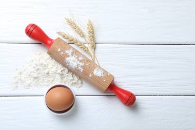 Yuvarlanan iğne, un, çiviler ve yumurta beyaz ahşap masada, düz yerde. Metin için boşluk