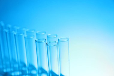 Açık mavi arka planda test tüpleri, metin için boşluk. Laboratuvar camları.
