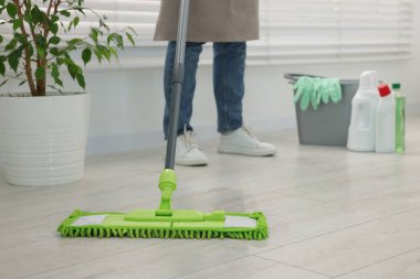 Yerleri mikrofiber paspasla temizleyen kadın, yakın plan.