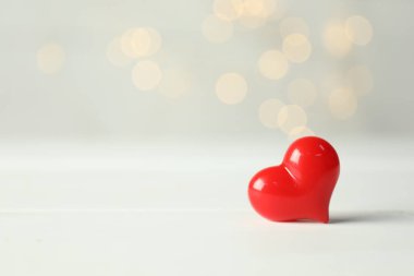 Sevgililer Günü. Beyaz ahşap arka planda dekoratif kalp, yakın plan. Bokeh etkisi