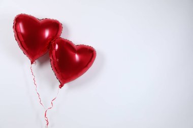 Işık arka planında kalp şeklinde kırmızı balonlar, mesaj için boşluk. Sevgililer Günü