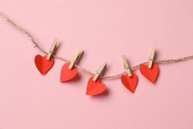 Sevgililer Günü. Pembe arka planda kağıt kalpli dizgi, üst görünüm