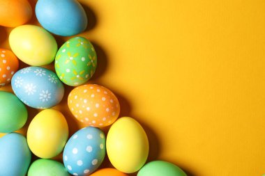 Turuncu arka planda güzel dekore edilmiş Paskalya yumurtaları. Metin için boşluk