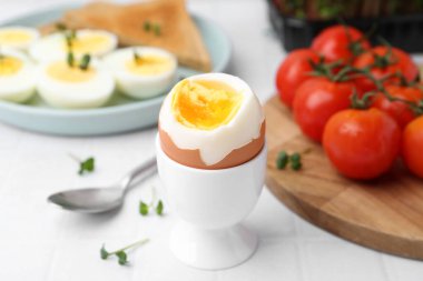 Beyaz fayanslı masada kaynamış yumurta, yakın plan.