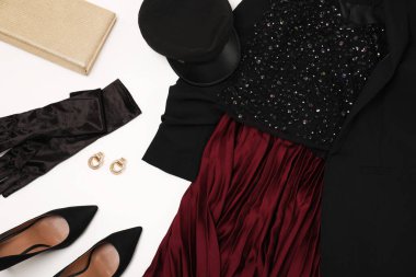 Beyaz arka planda şık kıyafetler, topuklu ayakkabılar ve aksesuarlar.