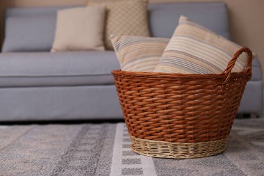 Oturma odasında yastıklı sepet.