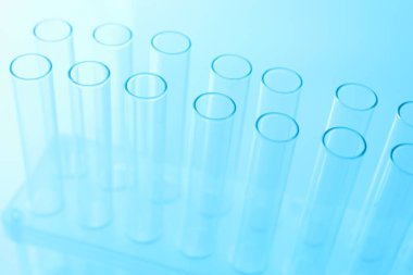 Açık mavi arka planda boş test tüpleri, yakın plan. Laboratuvar camları.