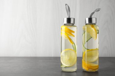 Gri masadaki şişelerde limon suyu, mesaj için yer.