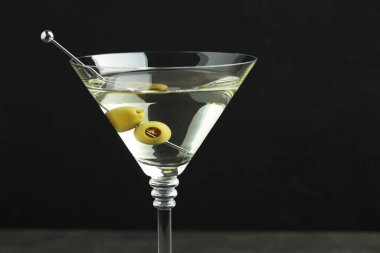 Siyah arka planda zeytinli martini kokteyli, yakın plan.