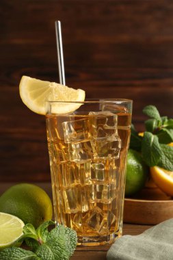 Buzlu çayı limon dilimi, kireç ve nane şekeri ile ahşap masada tazeliyorum. Yakın plan.