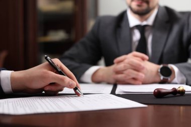Ofisteki masada noter ve istemci imzalama belgesi, seçici odak