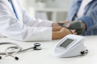 Hastanedeki randevu sırasında yaşlı adamın kan basıncını ölçen doktor, kapatıyor. Seçici odak