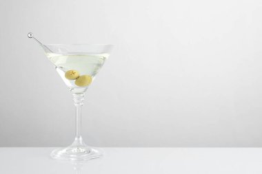 Zeytinli martini kokteyli. Işık masasında, metin için yer var.