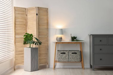 Beyaz duvarın yanında konsol masası olan şık bir oda.