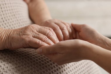 Son sınıf öğrencisine arka planda destek veren bakıcı, yakın plan. Yaşlı bakımı