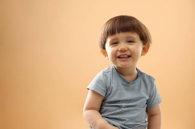 Bej arka planda gülümseyen küçük çocuğun portresi. Metin için boşluk