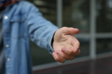 Yardım teklif ediyorum. Adam elini dışarı uzatıyor, yakın plan.
