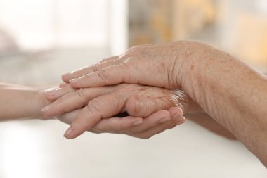 Son sınıf öğrencisine arka planda destek veren bakıcı, yakın plan. Yaşlı bakımı