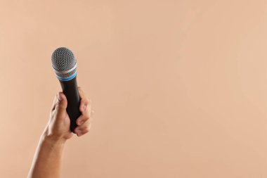 Bej arka planda mikrofonu olan adam, yakın plan. Metin için boşluk