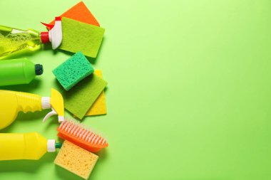 Yeşil arka planda temizlik ürünleri ve araçlar, düz yatak. Metin için boşluk