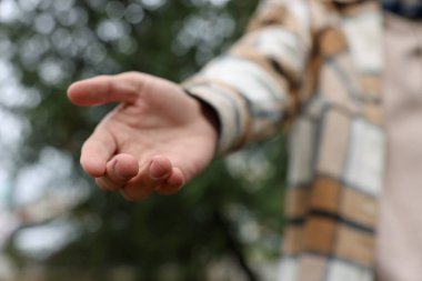 Yardım teklif ediyorum. Adam elini dışarı uzatıyor, yakın plan.