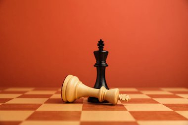 Satranç tahtasının ortasındaki siyah satranç kralı neredeyse düşmüş. Rekabet konsepti