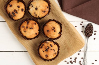 Beyaz ahşap masa üzerinde çikolata parçalı lezzetli kek, düz yatıyordu.