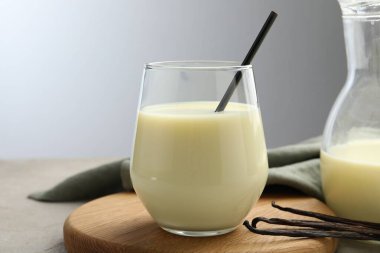 Gri masadaki lezzetli vanilyalı süt ve kapsüller