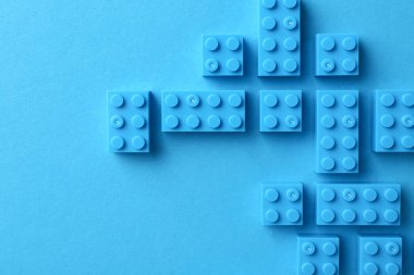 İnşaat oyuncağı. Açık mavi arkaplan üzerinde birçok yapı taşı, düz yatıyordu