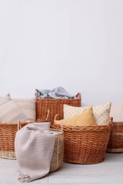 İçinde yastıklar ve battaniyeler olan birçok farklı hasır sepetler.