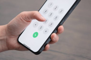 Akıllı telefondan arka plandaki bulanık numaraya çeviren kadın, yakın plan