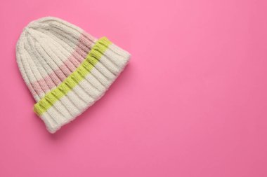 Pembe arka planda sıcak yün şapka, üst manzara. Metin için boşluk