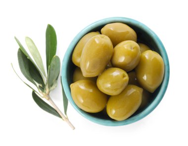 Lezzetli marine edilmiş yeşil zeytinler kasede ve beyaz yapraklar, üst manzara