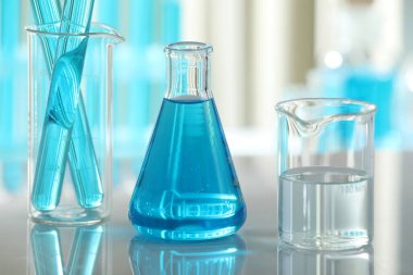 Ayna yüzeyinde sıvı bulunan laboratuvar camları, yakın plan.