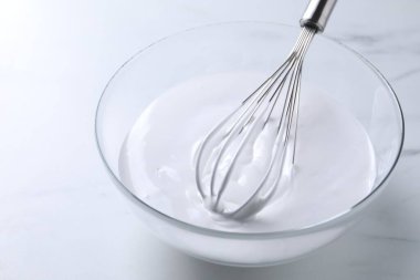 Beyaz mermer masada çırpılmış krema, yakın plan.