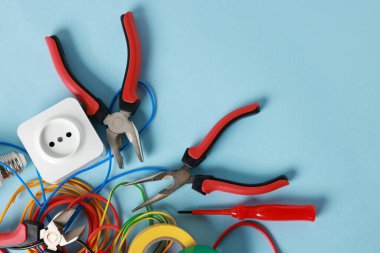 Açık mavi arka planda, düz zeminde farklı elektrikli aletler. Metin için boşluk