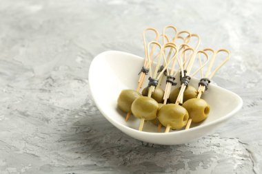 Gri dokulu masada salamura edilmiş zeytinler, yakın plan. Metin için boşluk