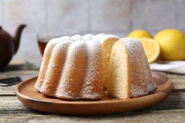 Tahta masaya pudra şekerli lezzetli limonlu pasta, yakın plan.