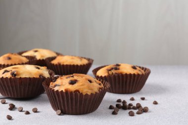 Açık gri masada çikolata parçalı lezzetli kek, yakın plan.