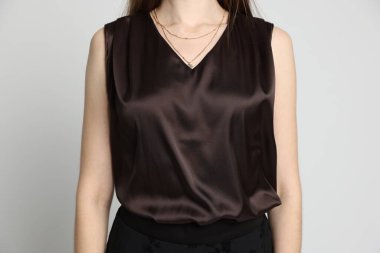 Beyaz arka planda şık giyinmiş güzel bir kadın, yakın plan.