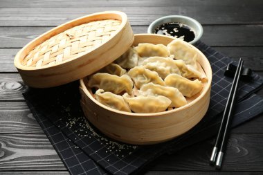 Lezzetli haşlanmış gyoza (hamur tatlısı) siyah ahşap masada servis edilir.
