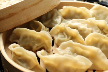 Bambu buharlı tencerede kaynamış gyoza (hamur tatlısı), yakın plan.