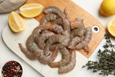 Taze çiğ karidesler, baharatlar ve limonlar beyaz masada, düz yatıyordu.