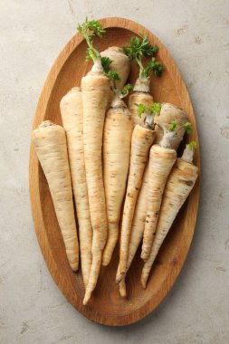 Gri masa üzerinde taze maydanoz kökleri, üst manzara