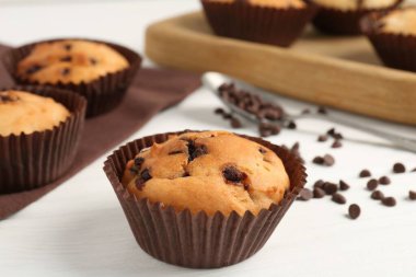 Beyaz ahşap masa üzerinde çikolata parçalı lezzetli kek, yakın plan.