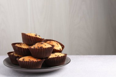 Açık gri masada çikolata parçalı lezzetli kek, metin için yer var.