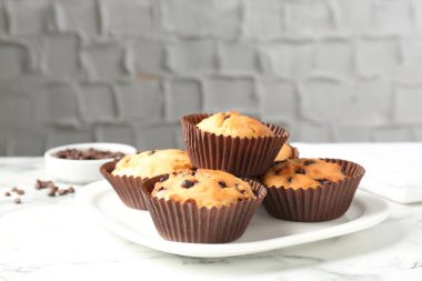 Beyaz mermer masa üzerinde çikolata parçalı lezzetli kek, yakın plan.