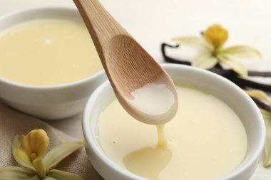 Lezzetli vanilyalı yoğunlaştırılmış sütü beyaz masadaki kaşıktan kaşığa alıp yakın plan çekiyoruz.