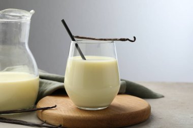 Gri masadaki lezzetli vanilyalı süt ve kapsüller