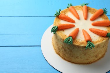 Açık mavi ahşap masada nefis ev yapımı havuçlu kek, metin için yer var.